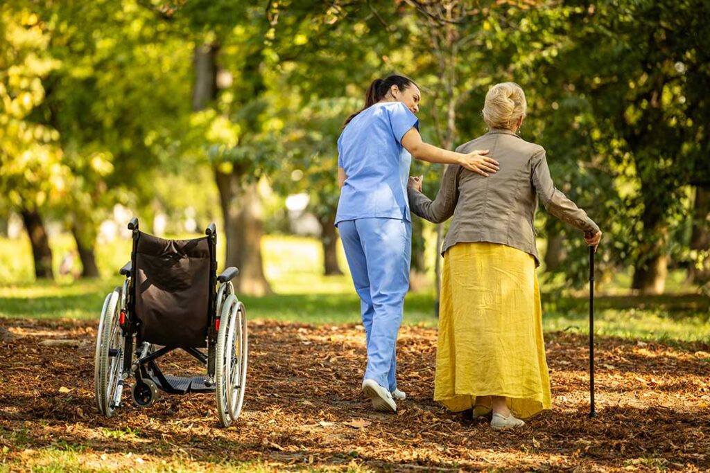 Resident arranging family photos and a favorite chair in a bright assisted living room.