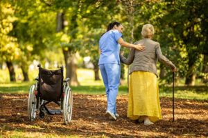 Resident arranging family photos and a favorite chair in a bright assisted living room.