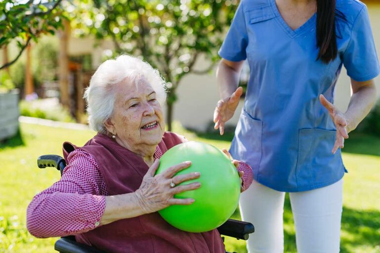 Caregiver and senior resident review a personalized care plan at a table in a bright living area.